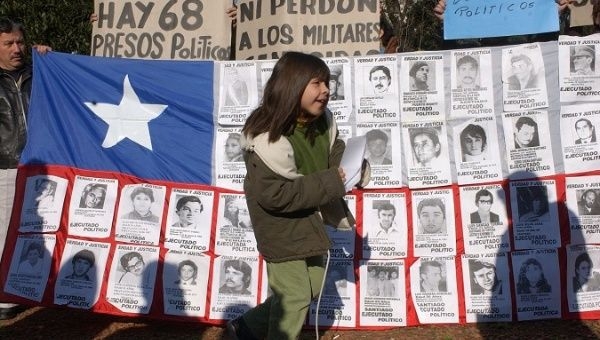 A Chilean flag featuring victims of the dictatorship on the anniversary of the coup that brought Pinochet to power, 2003.